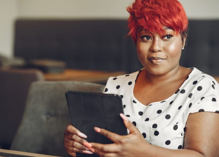 Young African American female working in an office. Lady in a white blouse.